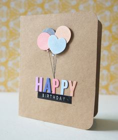 a birthday card with balloons and the word happy written on it in pink, blue, gray, and white