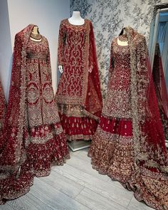 three red bridal gowns are on display