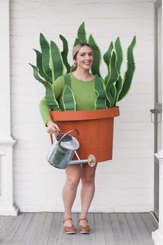 a woman holding a potted plant and watering can