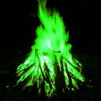 a green fire is lit up in the dark