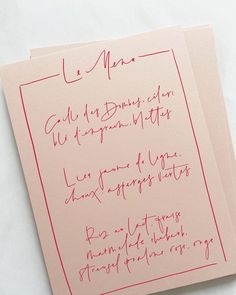 two pieces of pink paper with red ink on them and one piece of white paper that has writing on it