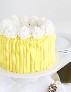 a yellow cake with white frosting on a plate