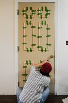 a young man is working on an art project with pegs attached to the door