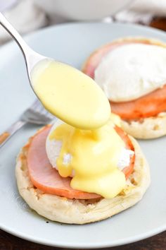 a spoon drizzling mayonnaise onto an english muffin