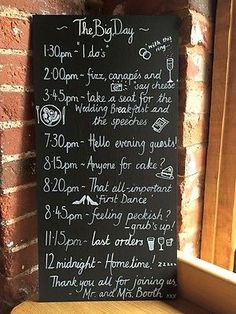 a chalkboard sign on the side of a brick wall