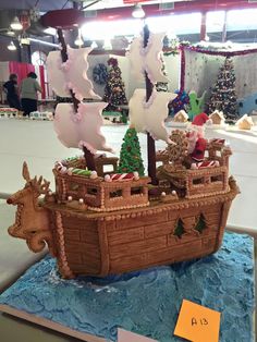 a cake shaped like a pirate ship with christmas decorations on it's sails and trees