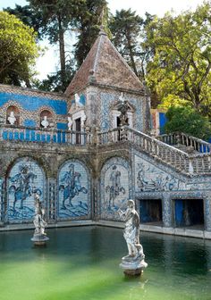 an ornate building with blue and white tiles on the outside, near a fountain in front of it