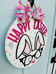 a happy easter door hanger hanging on a blue door with the words happy easter painted on it