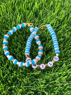 two blue and white beaded bracelets sitting on top of green grass