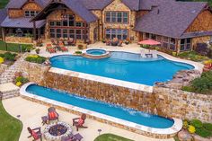 an aerial view of a home with a swimming pool and patio furniture in the foreground