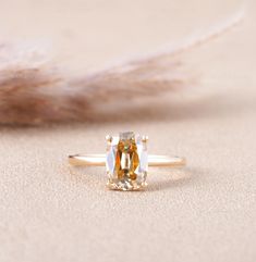 a ring with an orange diamond in the middle and a feather on the other side