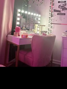 a desk with a mirror and lights on it in front of a pink wallpapered room