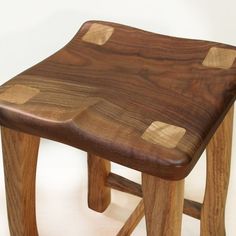 a wooden stool made out of wood with holes in it's seat and legs