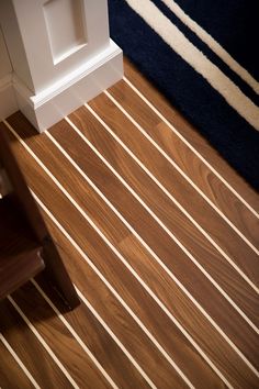 a wooden floor with white lines on it and a chair in the corner next to it