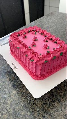 a pink cake sitting on top of a white plate