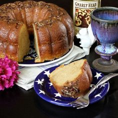 a bundt cake sitting on top of a blue plate next to a purple vase