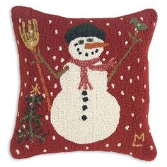 a red pillow with a snowman on the front and side, decorated with christmas decorations