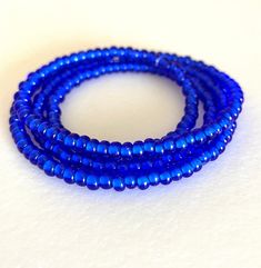 Men's 25 inch minimalist beaded necklace is dark transparent sapphire blue Czech glass. Premium Czech white heart beads are 3-4mm. Rondelles are beaded on nylon coated stainless steel professional beading wire. Necklace is 25 inches long with no clasp for easy wear. This is a skinny minimalist necklace for men or women. Minimalist Blue Beads For Gift, Blue Single Strand Minimalist Beaded Necklaces, Minimalist Single Strand Blue Beaded Necklace, Blue Single Strand Beaded Necklace With Czech Glass, Blue Glass Jewelry With Heart Beads, Elegant Blue Glass Necklaces, Blue Glass Heart Beads Jewelry, Elegant Sapphire Beaded Necklace, Adjustable, Blue Long Glass Necklace