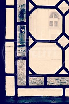 an old stained glass window with a building in the background