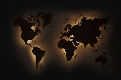 an illuminated world map in the dark with yellow light coming from it's sides