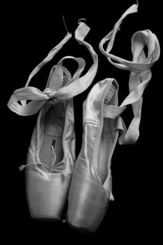 black and white photograph of ballet shoes with ribbons