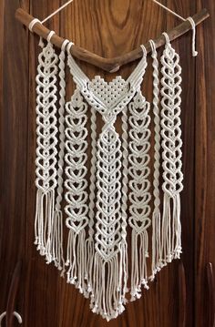 a white crocheted macrame hanging on a wooden wall