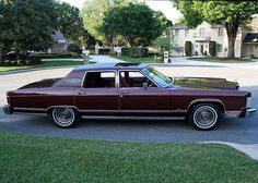 a maroon station wagon parked in front of a house