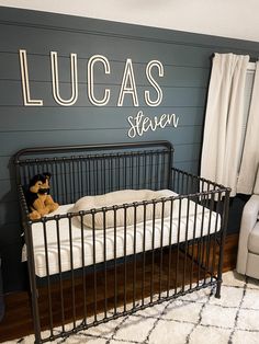 a baby's room with a black metal crib and white bedding