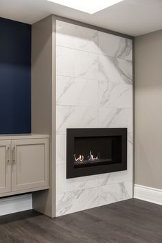 a fireplace in a room with white marble walls