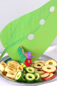 a plate filled with fruit and waffles next to a green leaf shaped object