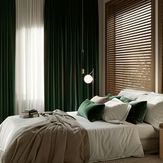 a bed with green and white pillows in a bedroom next to a window covered by curtains