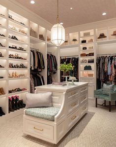 a walk in closet with lots of shoes on the shelves and a bench next to it