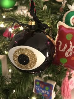 an ornament hanging on a christmas tree with ornaments around it and the eyeball