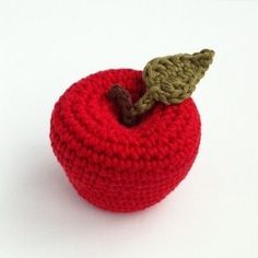 a crocheted apple sitting on top of a white table