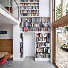 a room filled with lots of books next to a window