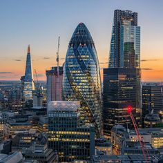 the london skyline at sunset with skyscrapers in the foreground and other tall buildings