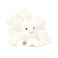 a white stuffed animal sitting on top of a white floor