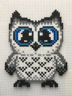 an owl made out of legos with blue eyes and black spots on it's face