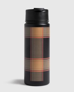 a black and tan plaid flask bottle on a grey background with the lid open