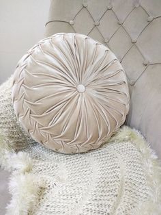 a round pillow sitting on top of a white couch