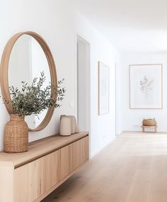 an empty room with a large round mirror on the wall and a wooden bench in front of it