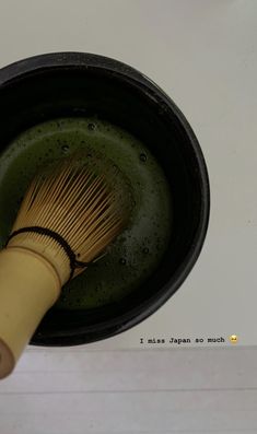 a wooden whisk in a black bowl on top of a stove