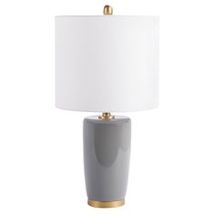 a gray table lamp with a white shade on top and gold trim around the base