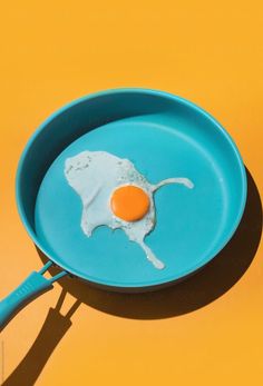 an egg yolk in a frying pan on a yellow background