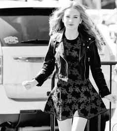 black and white photograph of a woman walking down the street