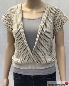 a female mannequin wearing a white top with crochet on the shoulders