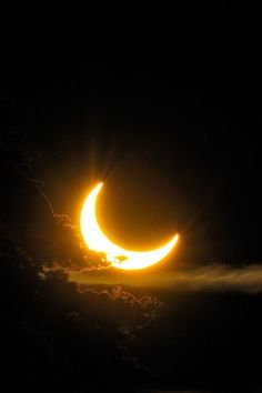 the moon is in the dark sky with clouds around it, and there are two eclipses visible