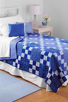 a blue and white quilted bedspread on a bed