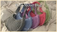 four crocheted purses sitting on top of a white sheet with the words half moon bag