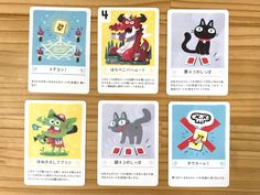 four cards with cartoon characters on them sitting on top of a wooden table next to each other